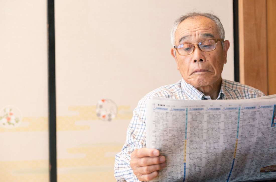 眼鏡をかけて新聞を読む男性