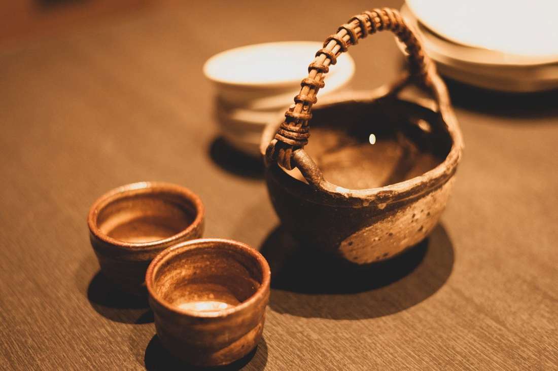 灯りの下に置かれた黒じょかと、焼酎の入った小さな器